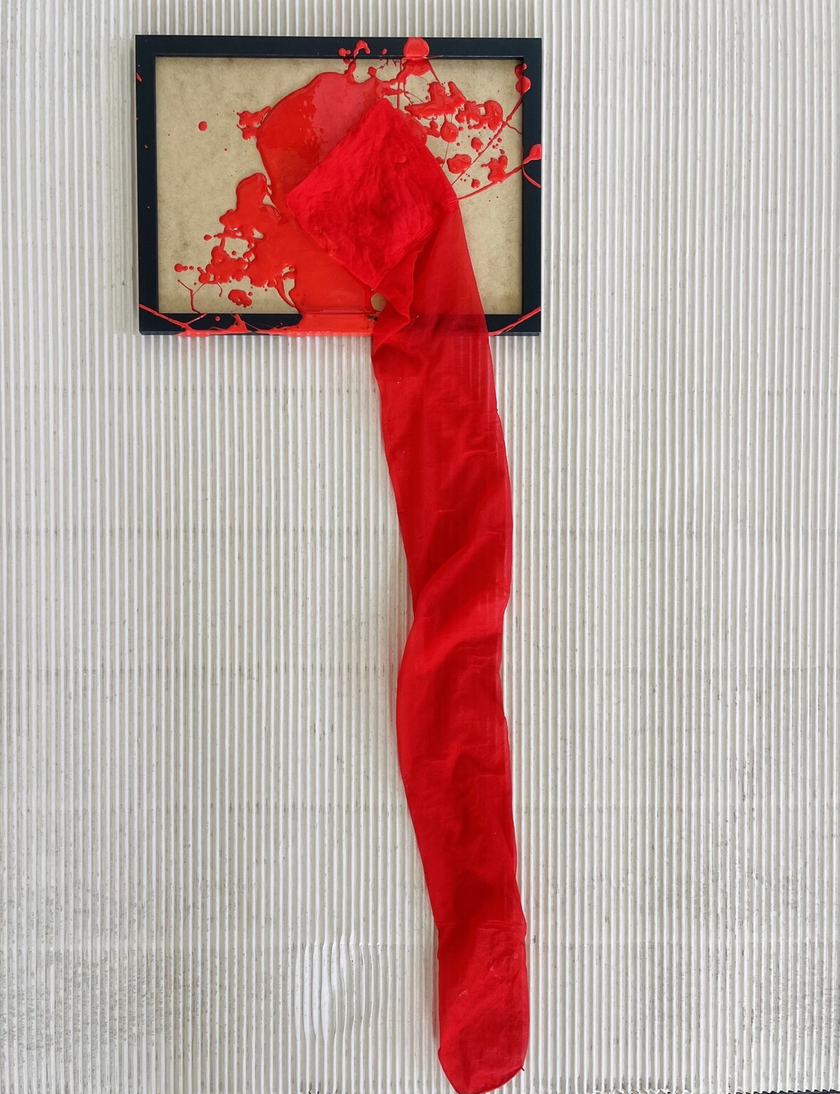 Red textile installation incorporating a military artefact
