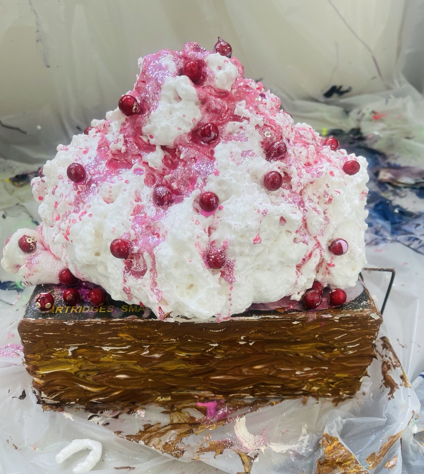 White and pink sculptural installation on an ammunition box